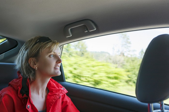 Woman looking through car window