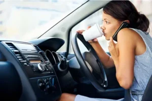 Distracted driver drinking coffee and using phone while driving in Oregon