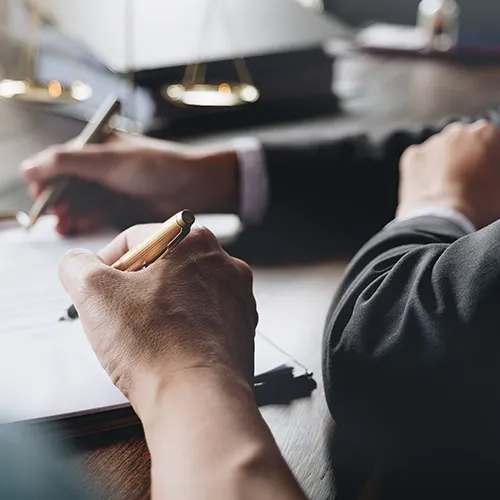 Lawyers collaborating at a desk while reviewing legal paperwork