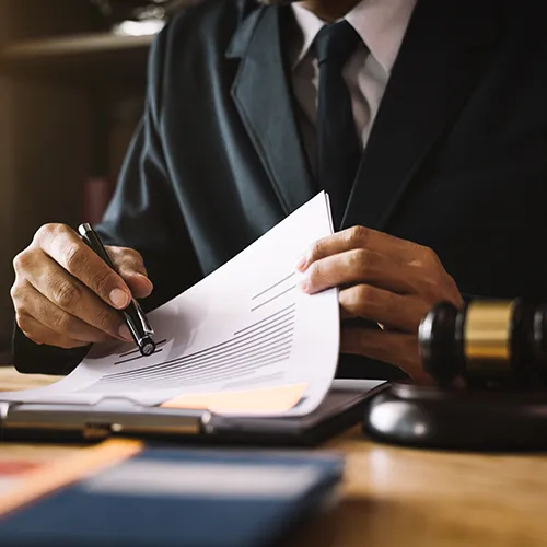 Legal professional reviewing paperwork with a pen in hand